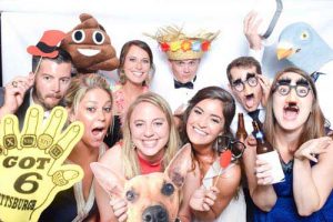 Silly guests of a wedding take pictures in the photo booth
