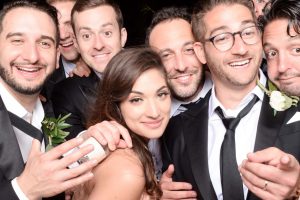 6 guys and a woman take pictures with the groom